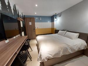 安平商旅Choona Hotel Anping في آنبينغ: غرفة نوم فيها سرير ومكتب