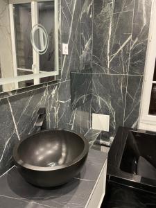 a bathroom with a large bowl sink on a counter at Proche Paris - Style Bali 350 m gare Mantes in Mantes-la-Jolie