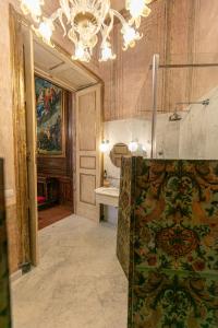 a large bathroom with a sink and a chandelier at Palazzo Doria Napoli in Naples