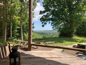 - une aire de pique-nique avec bancs et vue sur un champ dans l'établissement Barefoot Yurts, à Brede