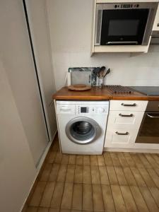 a kitchen with a washing machine and a microwave at Paris 15 jardin parking privé à côté de la Porte de Versailles in Paris