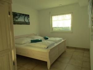 a bedroom with a wooden bed with a window at Villa Kleine Welle in Trent