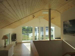 a living room with aamed ceilings and a large window at Villa Kleine Welle in Trent