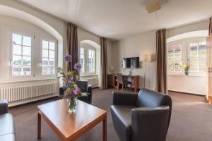 ein Wohnzimmer mit einer Blumenvase auf dem Tisch in der Unterkunft Hôtel de la Rose in Freiburg im Üechtland