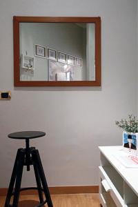 a mirror on a wall with a stool in a room at Gelso in Rome
