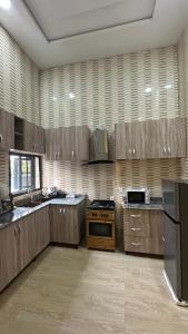 a large kitchen with wooden cabinets and a stove at Geminge shortlet in Port Harcourt
