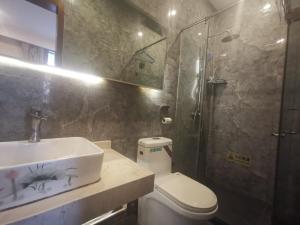 a bathroom with a sink and a shower and a toilet at Beijing Huiqing Garden Bussiness Hotel in Beijing