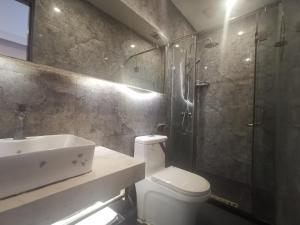 a bathroom with a toilet and a sink and a shower at Beijing Huiqing Garden Bussiness Hotel in Beijing
