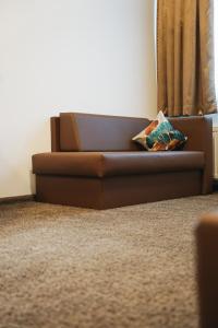 a brown couch in a living room with a window at Outlet Hotel in Metzingen