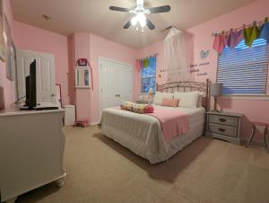 a pink bedroom with a bed and a flat screen tv at Chateau Relaxo Concord in Huntersville