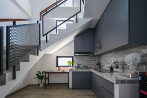 雅加達的住宿－Cove River Haus，厨房配有黑色橱柜和楼梯