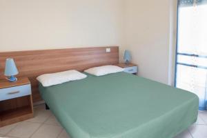 1 dormitorio con 1 cama verde grande y 2 almohadas en Bilocale fronte mare a Marcelli – M030, en Marcelli