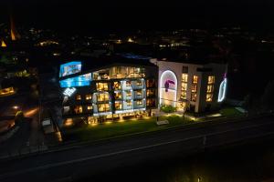 Lifesteil Aparthotel في امهاوسن: إطلالة ليلية على مبنى مع إضاءة