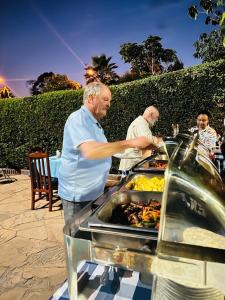 a man is preparing food at a buffet at Green Mountain Hotel in Arusha