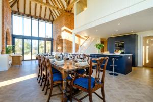 a dining room with a long table and chairs at Upper Barn in Ufford