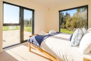 a bedroom with a bed and a large window at Upper Barn in Ufford