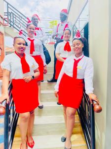 a group of women wearing red and white uniforms at Green Mountain Hotel in Arusha