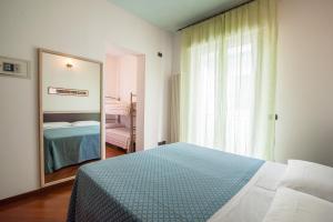 a bedroom with a bed and a large mirror at APPARTAMENTI SIVIGLIA in Cattolica
