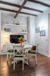 Un comedor blanco con una mesa y sillas blancas. en Accogliente intero appartamento, en Roma