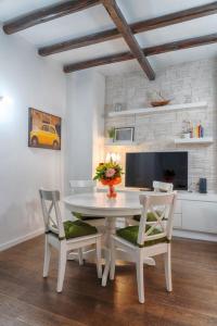 un comedor blanco con mesa y 2 sillas en Accogliente intero appartamento, en Roma