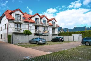 a house with two cars parked in front of it at Apartamenty Liliowa 3 in Dębki