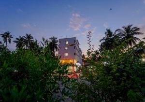 a tall building with palm trees in front of it at POP TAVERN Delight by VOYE HOMES in Veli