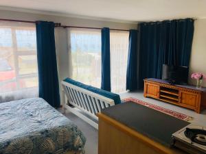 - une chambre avec un lit, un bureau et une télévision dans l'établissement Charming retreat in Danabaai, à Mossel Bay