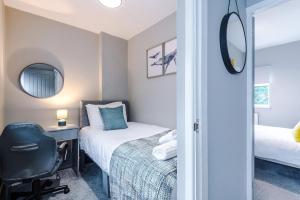 a bedroom with a bed and a desk and a chair at Poplar House- Contractor Friendly 3 Bedroom Bright Modern House with a Sofa Bed in Preston