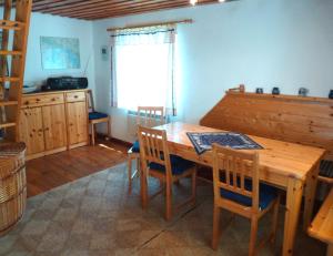 uma sala de jantar com uma mesa de madeira e cadeiras em Ferienhaus zum Plauer See em Zislow