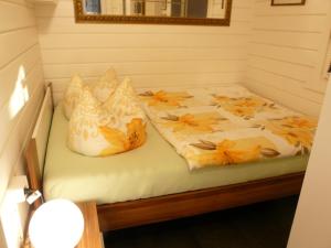 una cama con almohadas en una habitación en Ferienhaus direkt am See - a56012, en Dabel