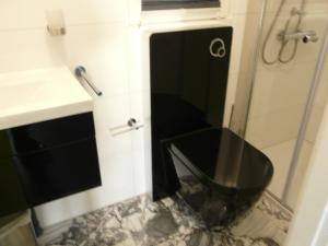 baño con aseo negro y lavamanos en Ferienhaus direkt am See - a56012, en Dabel