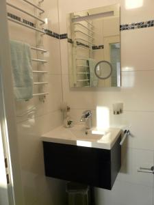 a white bathroom with a sink and a mirror at Ferienhaus direkt am See - a56012 in Dabel