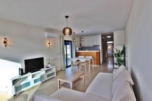 sala de estar y cocina con sofá y TV en Pé do Lago Apartment - Condominium - Pool, en Quarteira