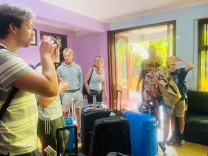 un grupo de personas de pie en una habitación con equipaje en Green Mountain Hotel, en Arusha