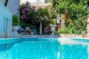 a swimming pool with blue water in a yard at Apartments Villa Aura in Dubrovnik