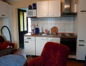 cocina con fregadero y silla roja en Ferienwohnung in Plau am See, en Plau am See