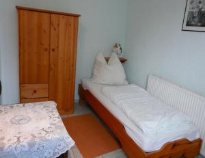 um pequeno quarto com uma cama e um armário de madeira em Ferienwohnung in Plau am See em Plau am See