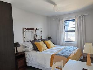 蠔灣的住宿－DAN EN WAN，一间卧室配有一张带黄色枕头的床和一扇窗户