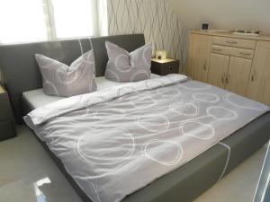 łóżko z białą pościelą i poduszkami w obiekcie Fewo direkt am See w mieście Dabel