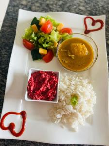 a plate of food with rice and a bowl of curry at Skyfly Bed & Breakfast in Manzini