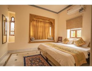 a bedroom with two beds and a window at Hotel Chouhan Palace, Jaisalmer, RJ in Jaisalmer