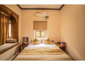 a bedroom with a bed with a window and a window at Hotel Chouhan Palace, Jaisalmer, RJ in Jaisalmer