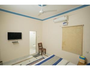 a room with a bed and a tv and a chair at Hotel Chouhan Palace, Jaisalmer, RJ in Jaisalmer