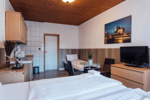 um quarto com uma cama e uma cozinha com uma televisão em Hotel Hanseat Hamburg em Hamburgo