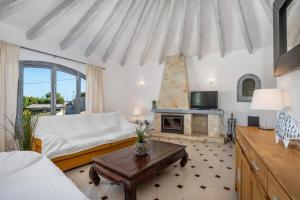 een slaapkamer met een bed en een open haard bij Villa Aloe - PlusHolidays in Calpe