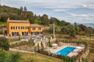 - une vue sur l'extérieur d'une maison jaune avec une piscine dans l'établissement Le Domaine Saint François La Tour 3, à Ajaccio