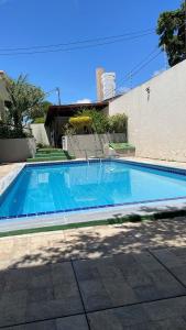 - une piscine d'eau bleue dans la cour dans l'établissement ACM Flat, à Natal