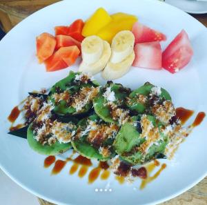 ein weißer Teller mit Essen und Obst darauf in der Unterkunft Vin vin in Ubud + 18 Fotos