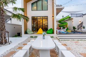 a house with a white table in the middle of a yard at 58/20 Pool Villa in Cha Am