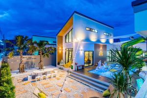 a house with palm trees in front of it at 58/20 Pool Villa in Cha Am